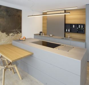 Exklusive Küche aus Stein mit Steinarbeitsplatte grau und Ansatztisch in Eiche Massivholz