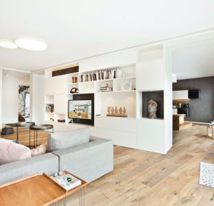 Offenes Wohnzimmer mit Couch hellgrau und Schrankwand für TV-Möbel